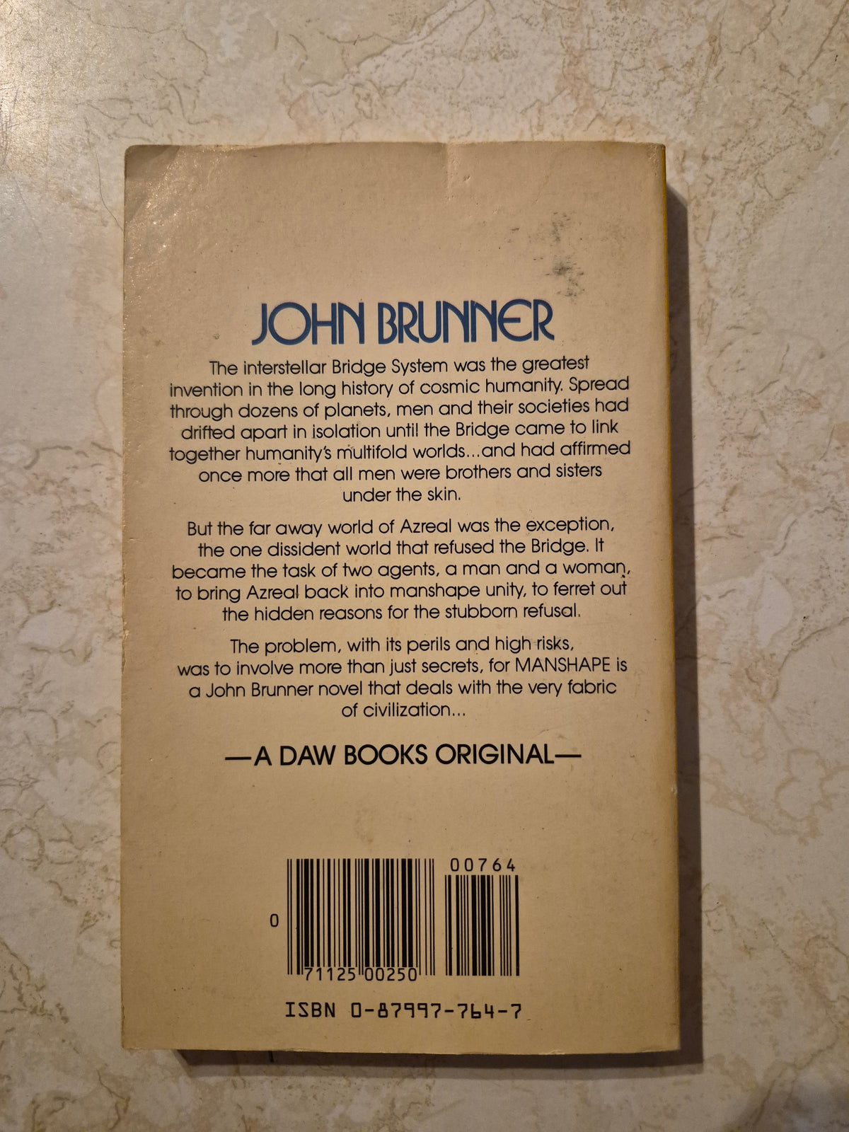 Back cover of Manshape by John Brunner showing synopsis, ISBN, and age marks
