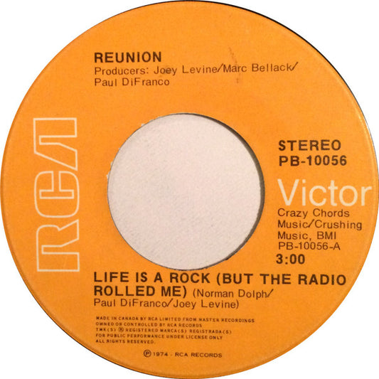 Reunion (3) : Life Is A Rock (But The Radio Rolled Me) (7", Single)